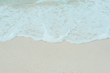 Turquoise waves of the Indian ocean run on the white beach of the island of Zanzibar