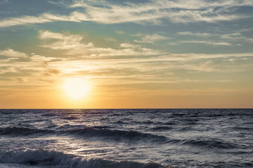 Panele Szklane Podświetlane  Seascape - słońce na horyzoncie wzburzonego morza o świcie