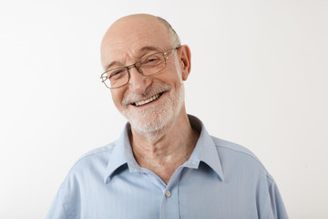 Happy emotional sixty year old man with bald head, gray stubble and wrinkled face having joyful...