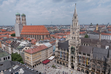 New City Hall and Frauenkirche Cathedral in the Marienplatz square of Munich, Germany are shown in a daytime, elevated view.