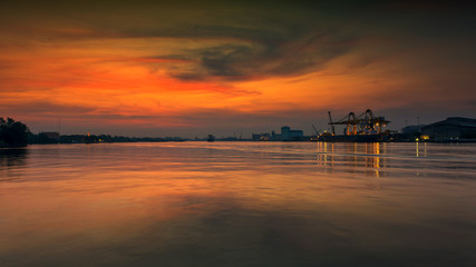 Fototapeta na wymiar river port with construction crane at dawn