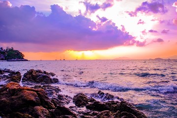 Obraz premium Beautiful scenic natural Evening scene seascape with cloud sunset Colors Over the sea Beach Rocks at lipe island Thailand,vivid and vibrant magenta color over the sea.