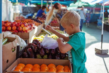 Boy buying vegetables on market