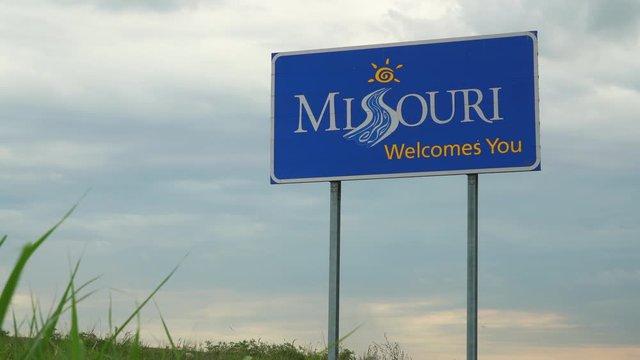 Welcomes You - roadside sign with highway traffic