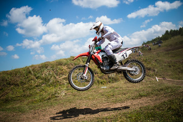 Fototapeta na wymiar A picture of a biker doing a trick, and jumping into the air. Motocross Championship. sports fast driving. bike large small.