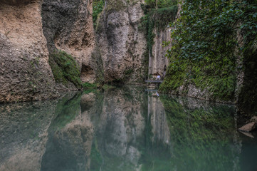 Reflective Water at the bottom of the canyon where the Bridge at Ronda is located in Andalucia, Spain