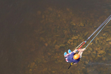 Rope jumping from high altitude of bridge. Bungee jumping from pedestrian bridge over beautiful...