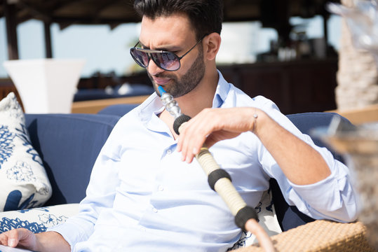 Expat man smoking sheesha at restaurant.