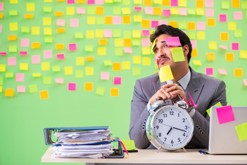 Businessman with many conflicting priorities in time management 