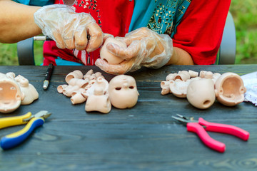 Female hands make dolls of BJD in the workplace. Processing the workpiece. The concept of the craft...