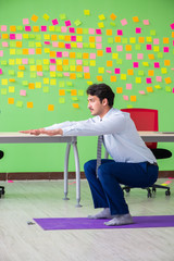Man in the office with many conflicting priorities doing exercis