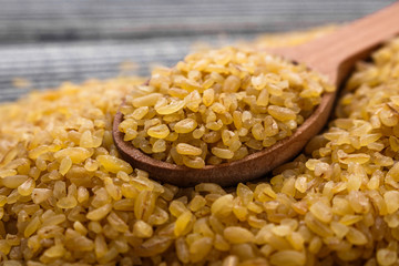 raw bulgur on a rustic wooden background