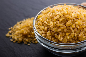 raw bulgur on a dark stone background
