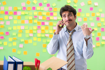 Man collecting his stuff after redundancy in the office with man
