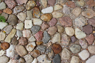 Background, texture - old ancient stone pavement of red, gray and white cobblestone