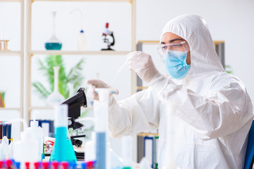 Young chemist student working in lab on chemicals