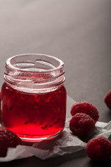 Raspberry jam in a jar with fresh raspberries. Copy space