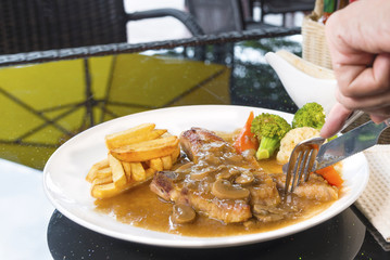 Juicy grilled pork steak and potatoes vegetables for restaurant menus healthy eating homemade with mushroom sauce on wooden table.