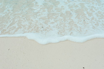 Turquoise waves of the Indian ocean run on the white beach of the island of Zanzibar