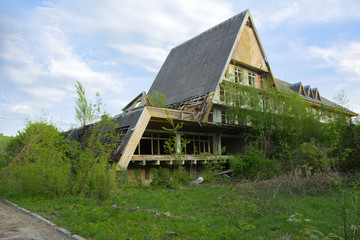 The ruins of an abandoned sanatorium of the times of the Soviet Union in middle of a dense forest. Destruction and vandalism. Broken construction stone construction. The building is lost in forest