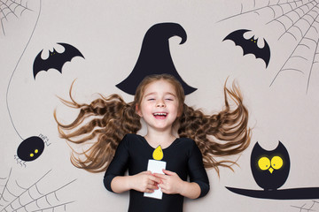 Funny child dressed witch costume. Halloween holidays concept