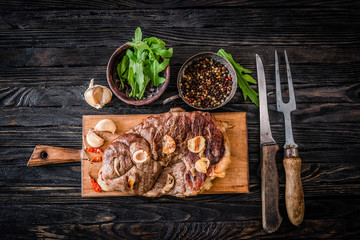 Grilled meat with garlic on a wooden board, top view