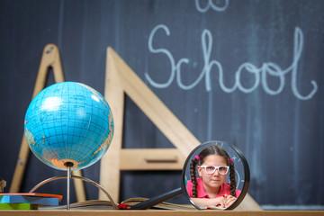 Happy school girl in front of the blackboard