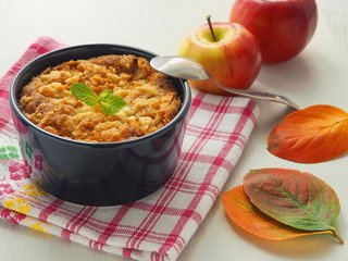 Portion of coffeecake in blue mug. Biscuit with autumn apples. Homemade crumble pie with streusel...