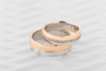 Two-tone wedding rings with diamonds on white background