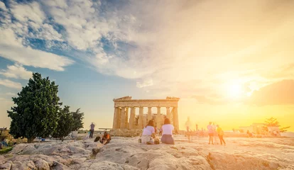 Wall murals Athens Tourists sitting on stones in front of Parthenon in the evening during sunset time, Athens, Greece. Picturesque sky at the Parthenon temple