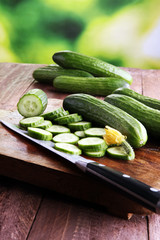 Fresh and sliced cucumbers. Sliced cucumbers on a cutting board.