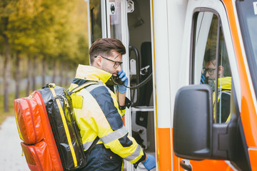 Emergency doctor using radio of ambulance for communication 