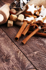 Christmas cookies and spices on brown wooden background.