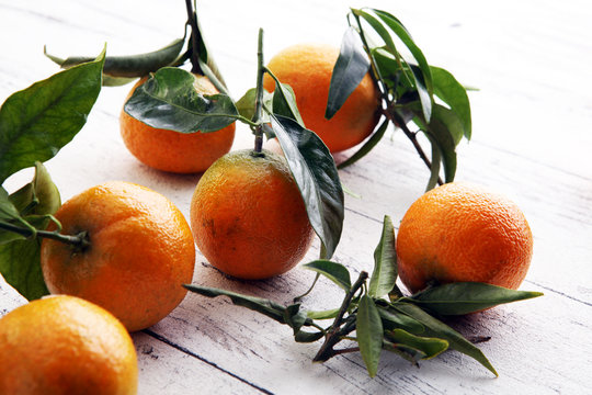 Tangerines with leaves on wooden background. Mandarins Rustic style