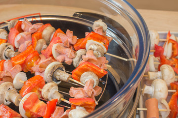 prepares healthy food in the kitchen. Cooking skewered mushrooms, Champignon process with...