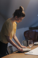 Woman Setting up Dinner Table