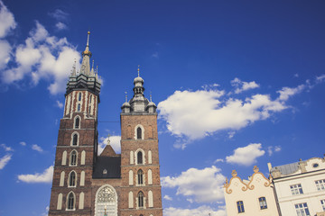 Fototapeta premium catholic church facade with towers in old city district on blue sky background with empty space for copy or text