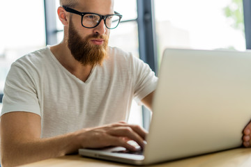 Handsome businessman working with laptop in office.