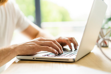 Business man using laptop computer. Male hand typing on laptop keyboard.
