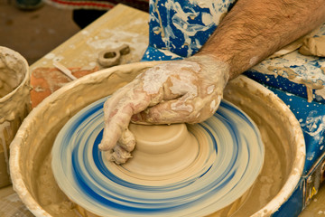 The potter's hands make a ceramic vase on a potter's wheel