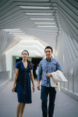Fototapeta premium A portrait of a young,happy and excited Chinese young couple walking on the airport hallway.