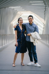 A portrait of a young and attractive Chinese Asian going on a trip. They are in their thirties and are both well-dressed.