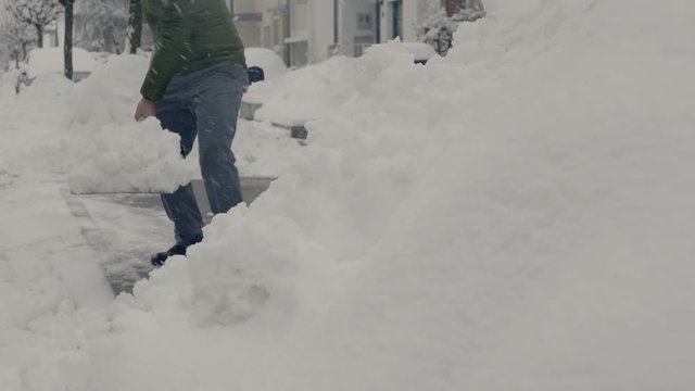 Low angle of a man shoveling.