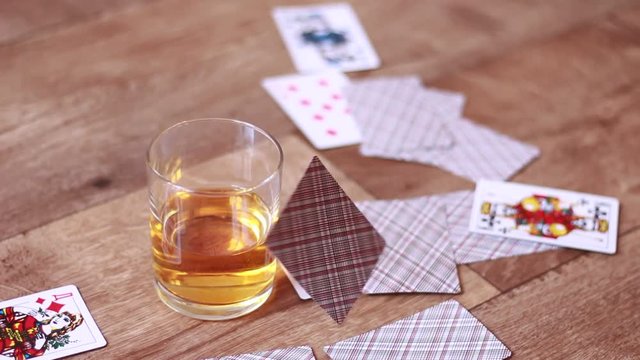 Falling playing cards over the glass with whisky