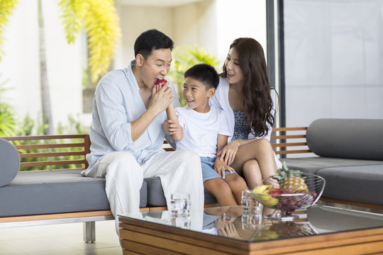 Happy young family eating fruit