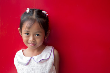 Cute asian little child girl on red background.
