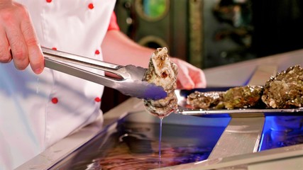 Chef taking out the shells from aquarium of seafood restaurant, close-up.