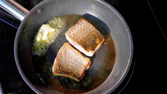 Pan-fried fish, Two pieces of loban fillet on the steaming frying pan.
