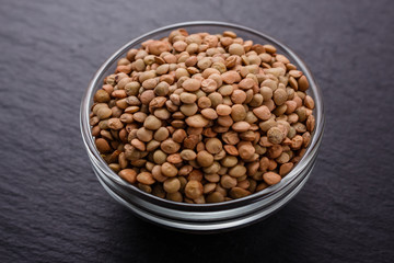 raw lentils on a dark stone background