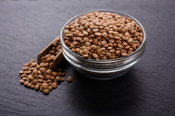 raw lentils on a dark stone background